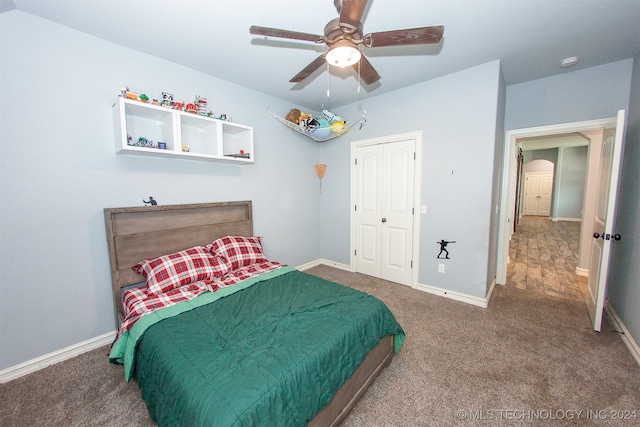 bedroom with ceiling fan, a closet, and carpet