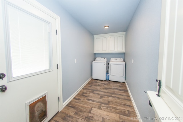 clothes washing area with cabinets, dark hardwood / wood-style floors, and washing machine and clothes dryer