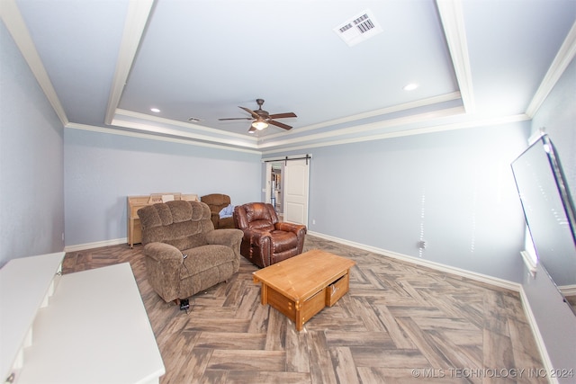 living area with parquet floors, a tray ceiling, ceiling fan, crown molding, and a barn door