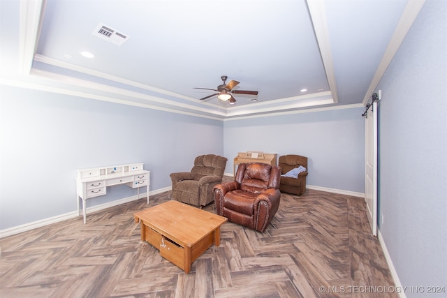 interior space featuring ceiling fan, a raised ceiling, a barn door, parquet flooring, and crown molding