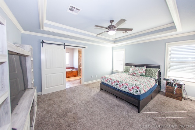 bedroom featuring ensuite bath, ceiling fan, a barn door, a tray ceiling, and carpet floors