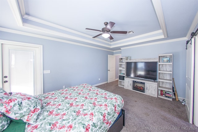 bedroom featuring carpet flooring, ceiling fan, a barn door, crown molding, and a tray ceiling