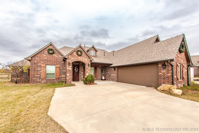 view of front of property featuring a garage and a front lawn