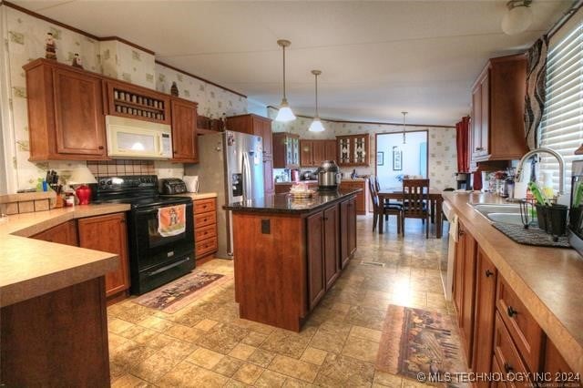 kitchen with stainless steel appliances, sink, a center island, hanging light fixtures, and lofted ceiling