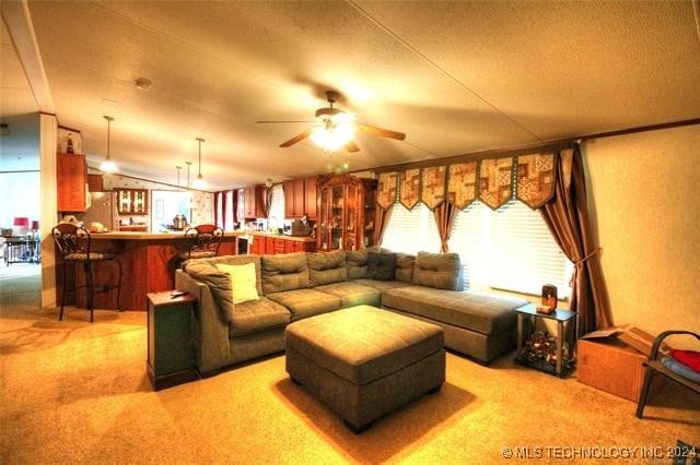 carpeted living room featuring lofted ceiling, bar, ceiling fan, and a textured ceiling