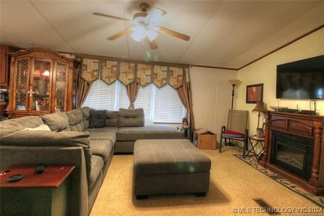 carpeted living room with ceiling fan and vaulted ceiling