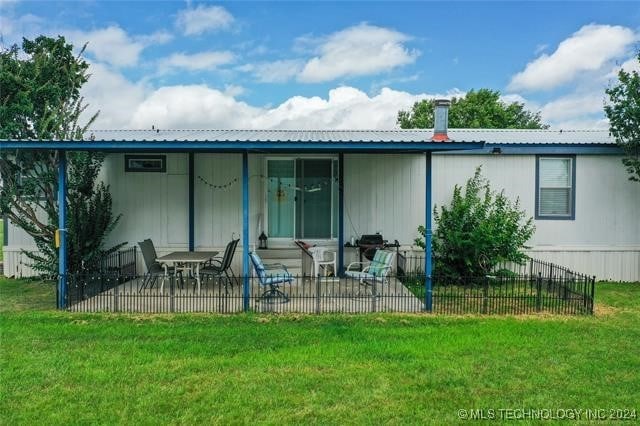 back of property featuring a yard and a patio