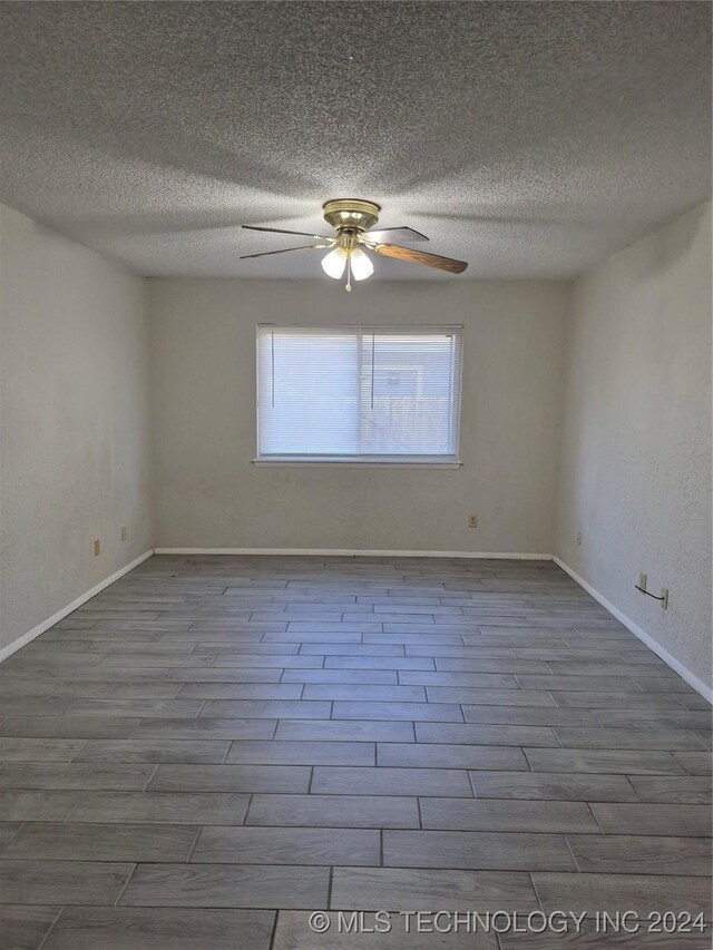 spare room with a textured ceiling, light hardwood / wood-style flooring, and ceiling fan