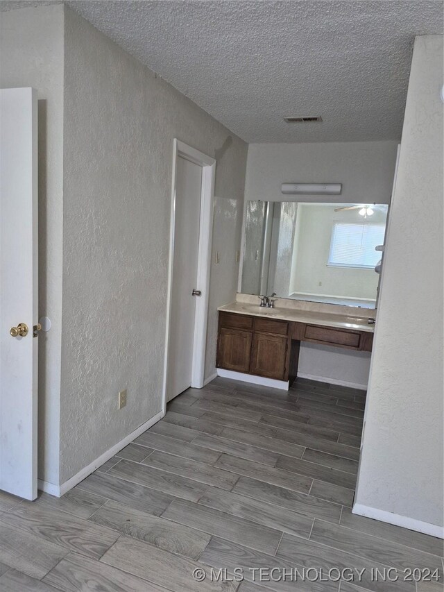 bathroom featuring a textured ceiling, vanity, and hardwood / wood-style flooring