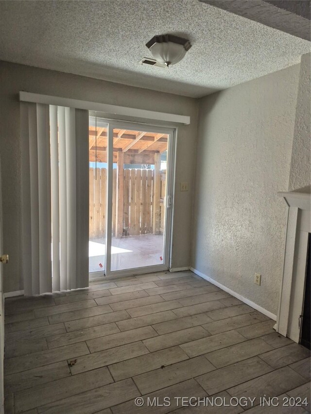 interior space with a textured ceiling and hardwood / wood-style flooring