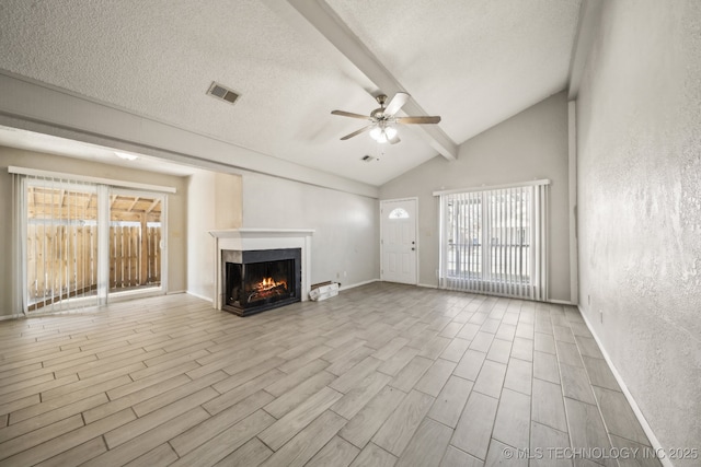 unfurnished living room with a textured ceiling, a multi sided fireplace, visible vents, beam ceiling, and wood tiled floor