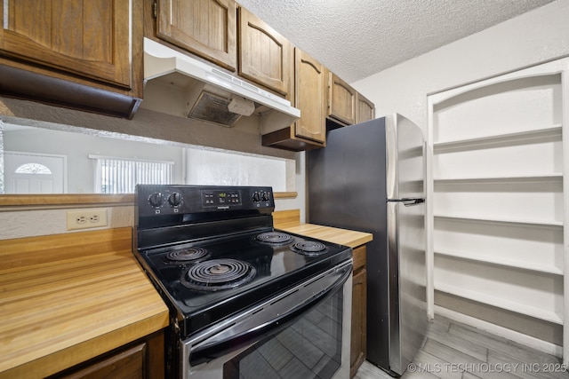 kitchen featuring a textured ceiling, black electric range, wooden counters, and under cabinet range hood