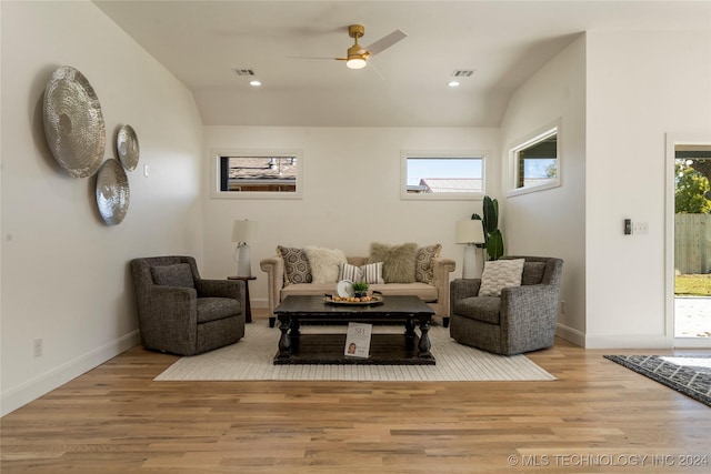 living room featuring ceiling fan, a healthy amount of sunlight, light wood-type flooring, and lofted ceiling