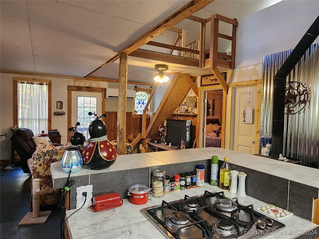 kitchen featuring a wall mounted AC, black gas stovetop, and ceiling fan