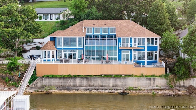 rear view of property with a water view and a balcony