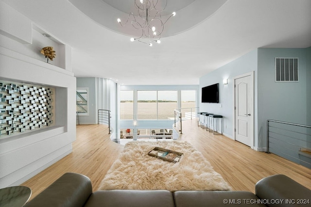 living room with an inviting chandelier and light wood-type flooring