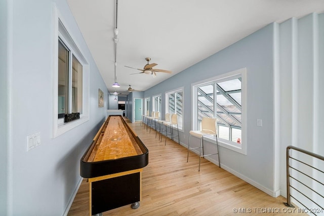 recreation room featuring vaulted ceiling, light hardwood / wood-style flooring, and ceiling fan