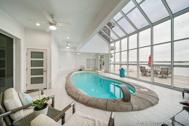 view of swimming pool with ceiling fan and a water view