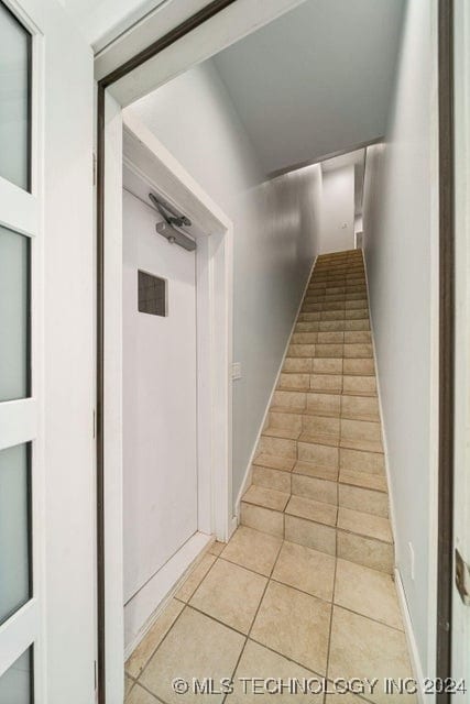 stairway with tile patterned flooring