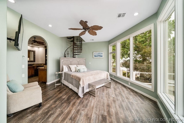 bedroom featuring ceiling fan, dark wood-type flooring, and connected bathroom