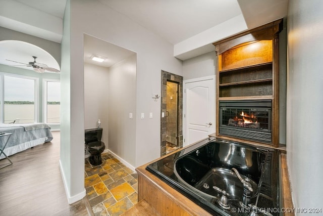 bathroom featuring ceiling fan and a bath