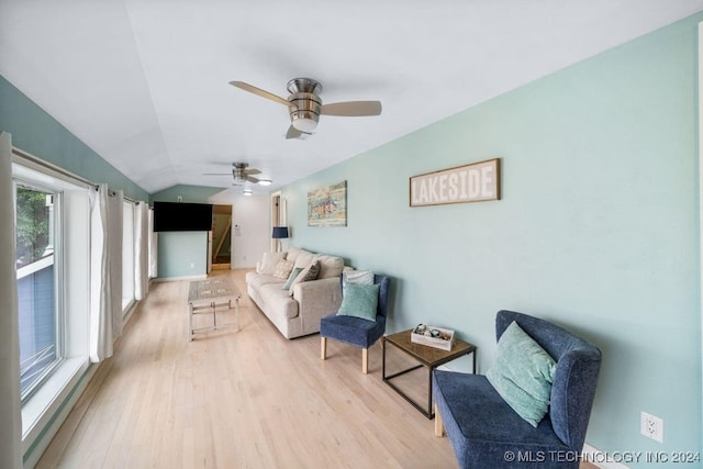 living room with plenty of natural light, ceiling fan, light hardwood / wood-style flooring, and vaulted ceiling