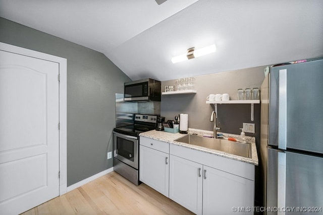 kitchen featuring sink, stainless steel appliances, light hardwood / wood-style floors, lofted ceiling, and white cabinets