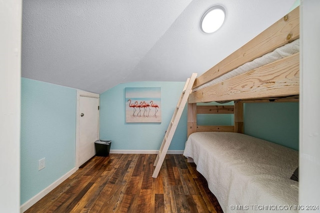 unfurnished bedroom with dark hardwood / wood-style flooring and lofted ceiling