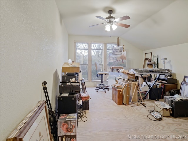 carpeted office space with ceiling fan and vaulted ceiling