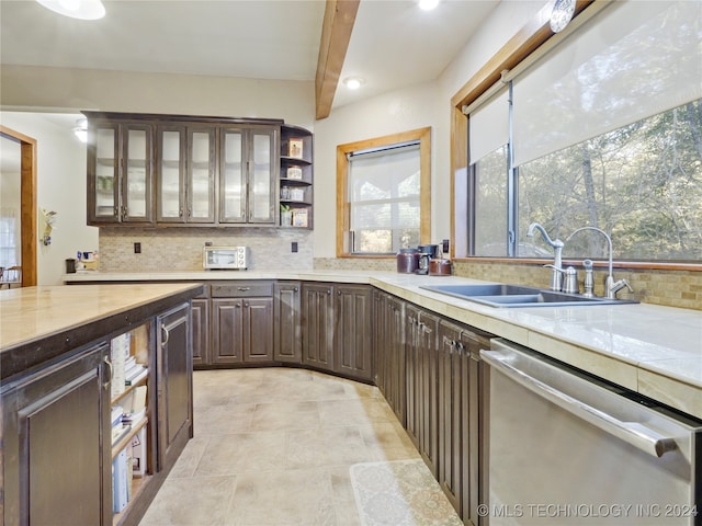 kitchen with dishwasher, backsplash, sink, beamed ceiling, and dark brown cabinets