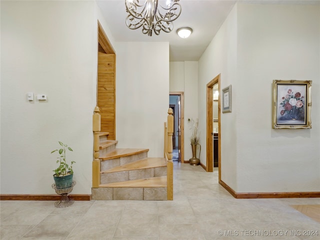 hallway featuring light tile patterned flooring and a notable chandelier