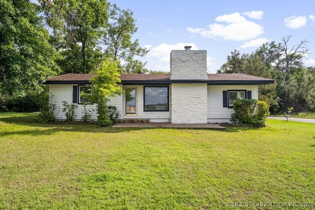 rear view of property featuring a yard