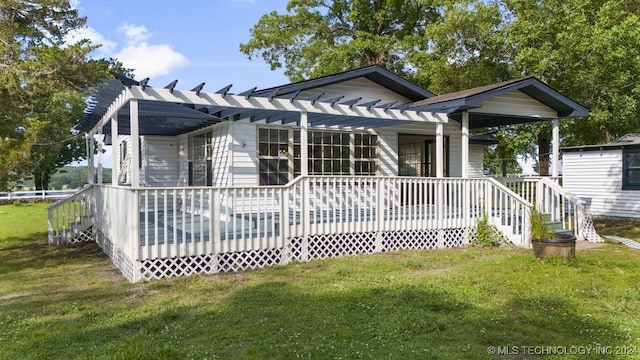 rear view of house with a porch and a yard