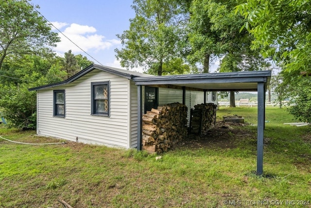 view of side of home featuring a lawn and a carport