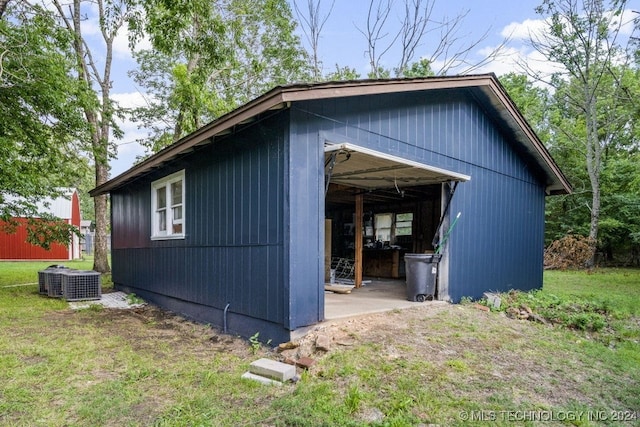 view of side of home with a yard, an outbuilding, and cooling unit