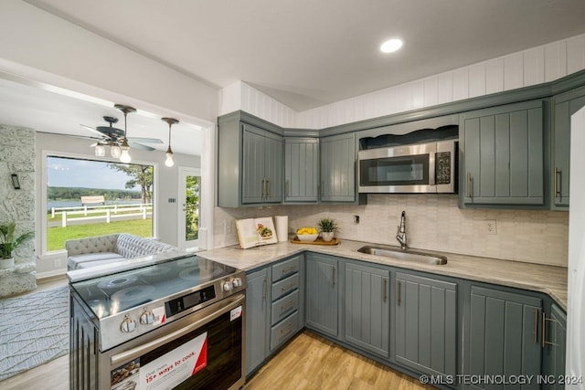 kitchen featuring gray cabinetry, sink, light wood-type flooring, and stainless steel appliances