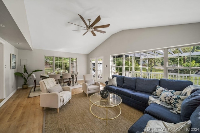 living room with hardwood / wood-style flooring, vaulted ceiling, and ceiling fan