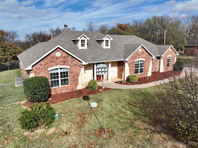 view of front of home featuring a front yard and cooling unit