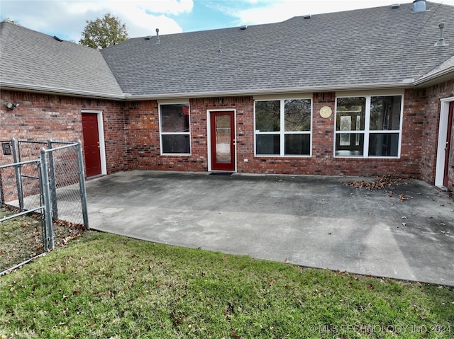 back of house with a lawn and a patio