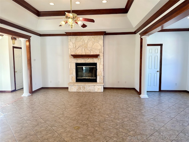 unfurnished living room featuring ceiling fan, ornamental molding, a fireplace, and decorative columns