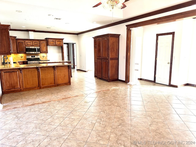 kitchen with tasteful backsplash, light stone counters, stainless steel appliances, ceiling fan, and crown molding