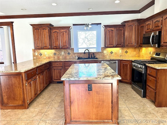 kitchen featuring ceiling fan, sink, kitchen peninsula, appliances with stainless steel finishes, and ornamental molding