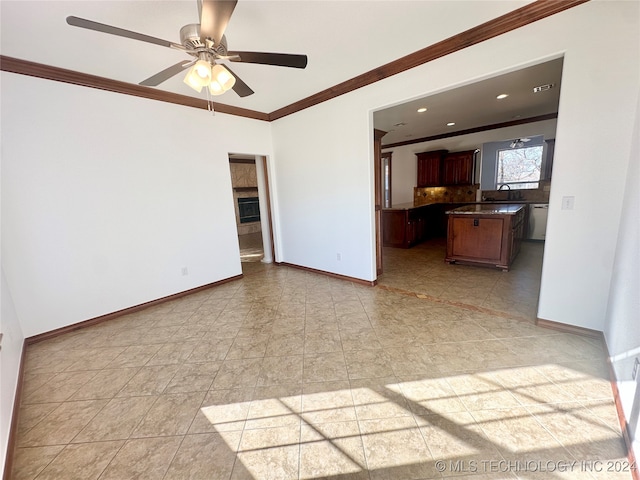 unfurnished living room featuring ceiling fan, crown molding, and light tile patterned flooring