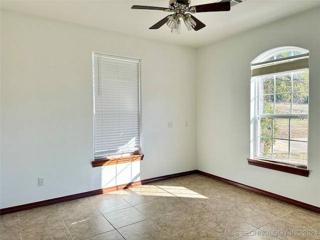 spare room featuring light tile patterned floors and ceiling fan