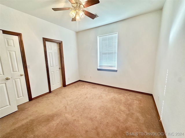 unfurnished bedroom featuring ceiling fan and light carpet