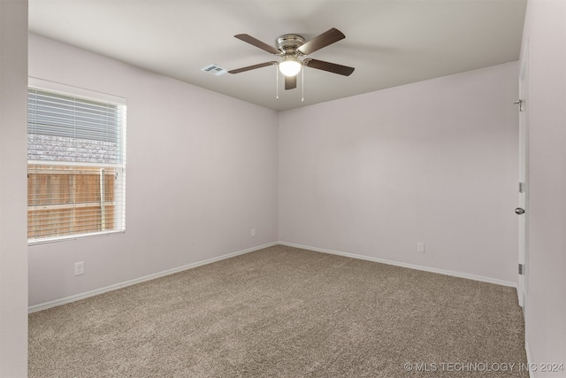 empty room with ceiling fan and light carpet