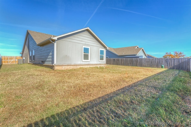 rear view of house featuring a lawn and cooling unit