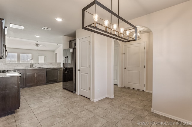 kitchen featuring light stone countertops, backsplash, stainless steel appliances, ceiling fan, and hanging light fixtures