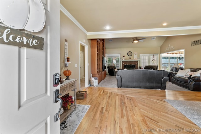 3103 Callaway Dr, Claremore, OK 74019 - foyer entrance featuring ornamental molding, a ceiling fan, a fireplace, healthy amount of natural light, and light wood-style flooring