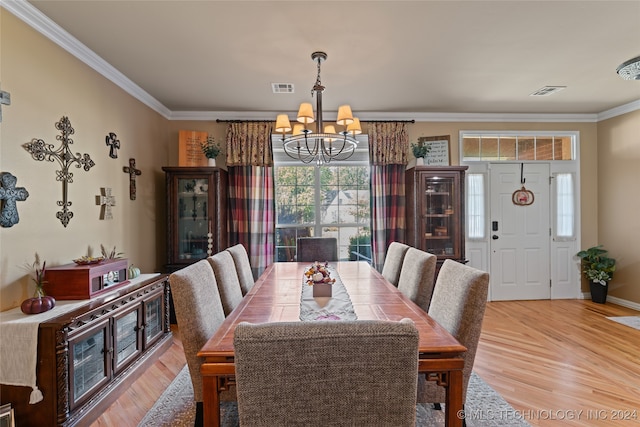 dining area featuring crown molding, hardwood / wood-style floors, and a notable chandelier